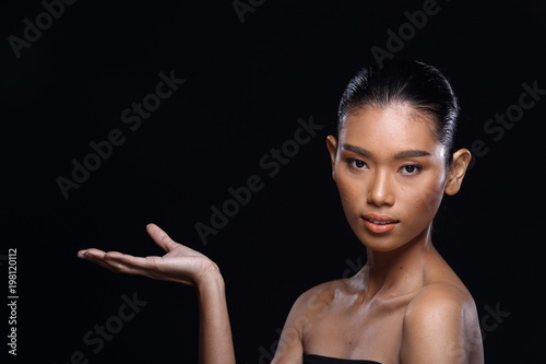 Tanned skin young fashion Asian woman model present showing empty copy space on her hand palm