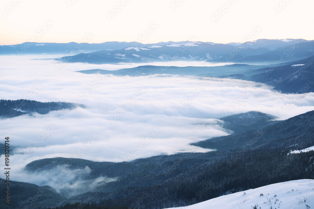 Beautiful landscape with foggy mountains in wintertime