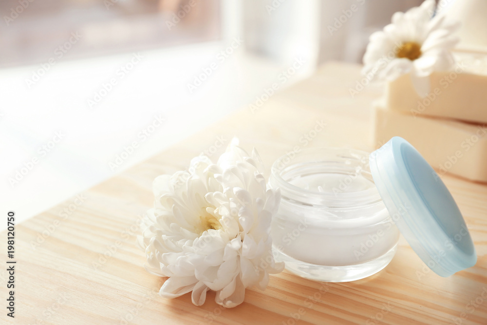 Jar with body care cream and flower on table Jar with body care cream and flower on table
