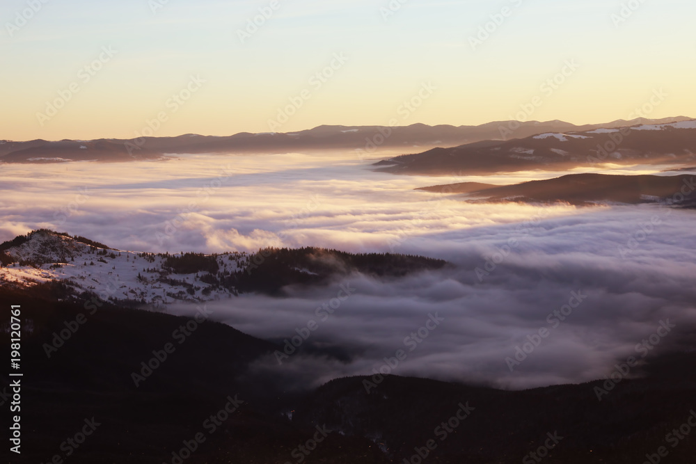 Fototapeta premium Beautiful landscape with foggy mountains in wintertime