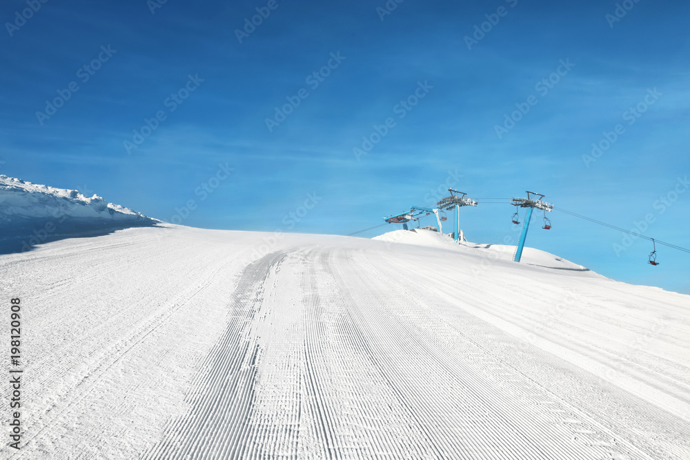 Ski piste with aerial ropeway at snowy resort. Winter vacation Ski piste with aerial ropeway at snowy resort. Winter vacation