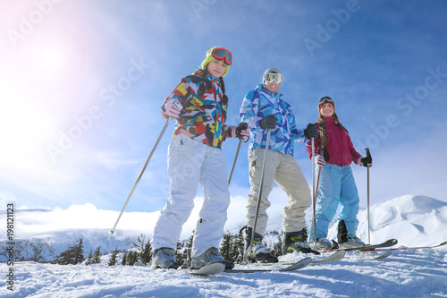 Friends on ski piste at snowy resort. Winter vacation