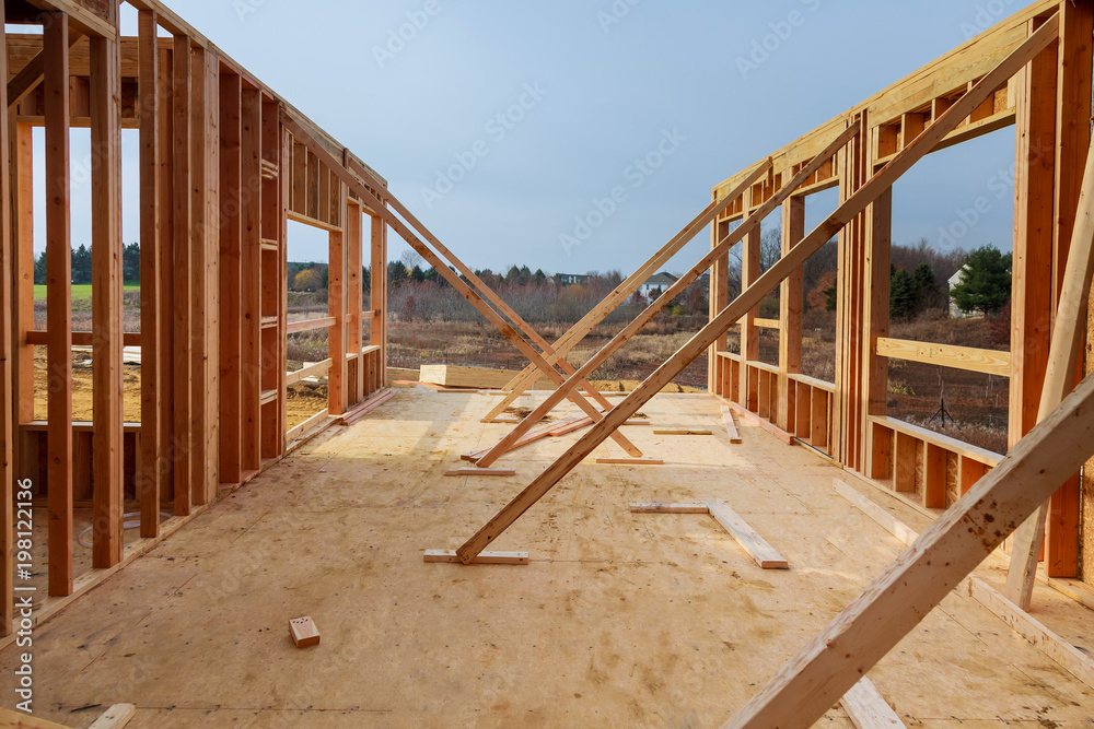New residential construction home framing against blue sky New residential construction home framing against blue sky