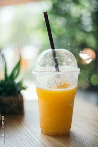 Orange juice smoothie glass on wood table