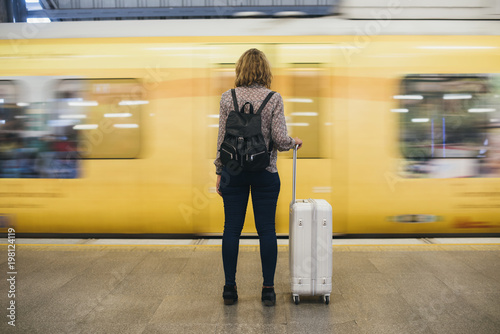Rear view of a blond woman waiting at the train platform