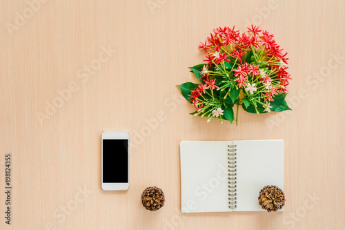 Coffee beans smartphone and flower on the brown table, copy space