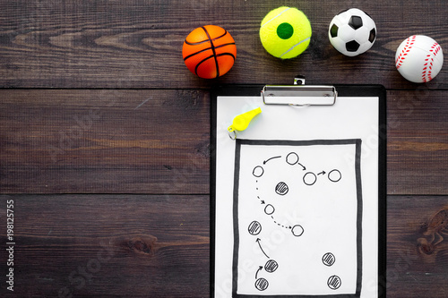 Sport coach concept. Pad with tactic plan of the match near whistle and balls on wooden background top view copy space © 9dreamstudio