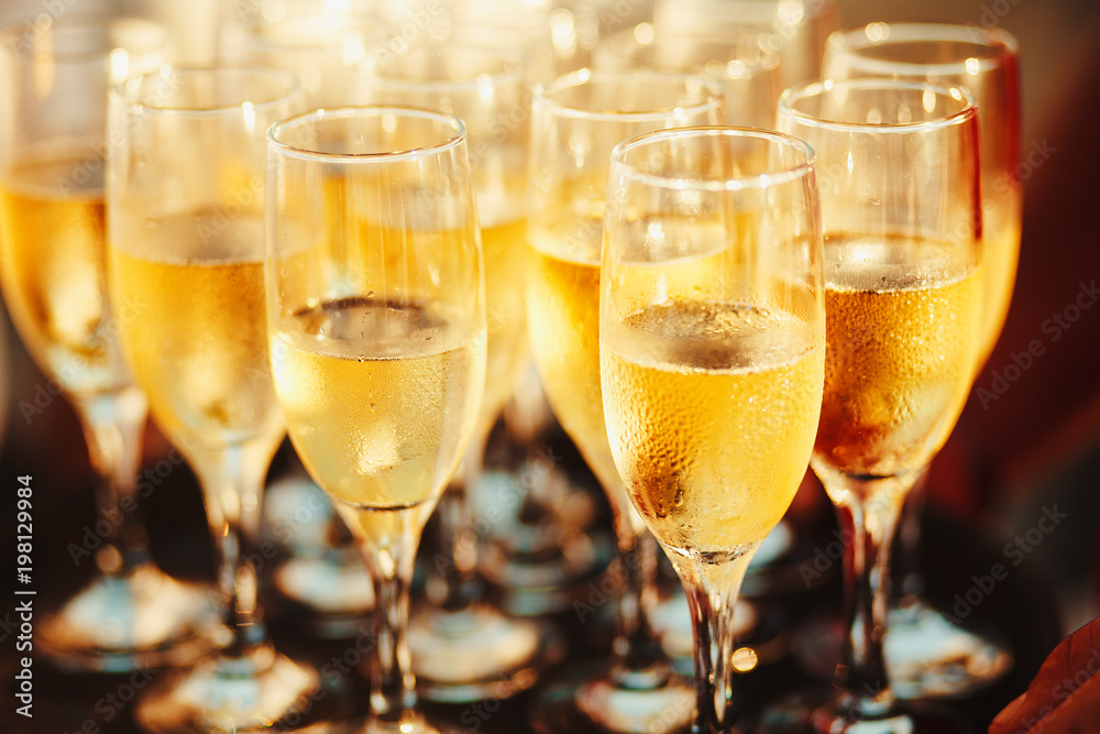 cold champagne on the tray. Sparkling wine poured by the glass. cold champagne on the tray. Sparkling wine poured by the glass.
