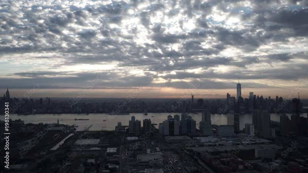 New York City wide angle aerial view of the Manhattan skyline from Jersey City, with sunbeams shining through the clouds. New York City wide angle aerial view of the Manhattan skyline from Jersey City, with sunbeams shining through the clouds.