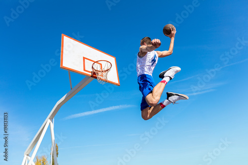 Young Basketball street player making slam dunk © FS-Stock