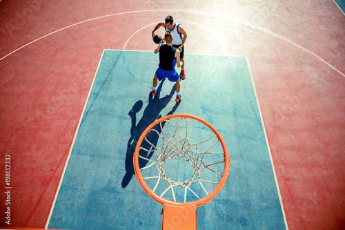 High angle view of basketball player dunking basketball in hoop photo