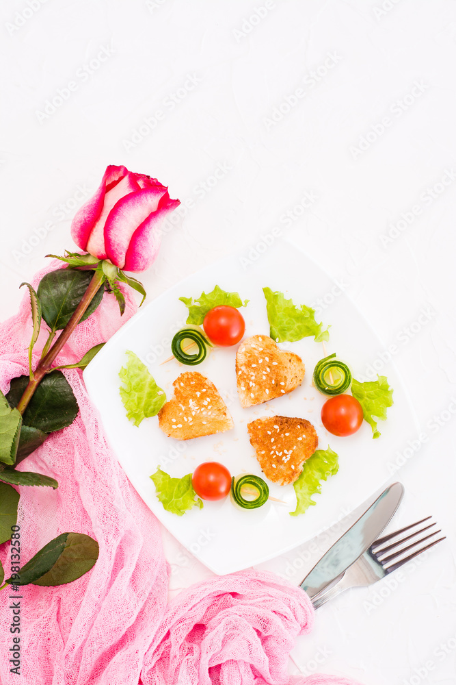 Toasts in the form of heart, cherry and cucumber on a plate. Dish served for lovers and rose. Top view Toasts in the form of heart, cherry and cucumber on a plate. Dish served for lovers and rose. Top view