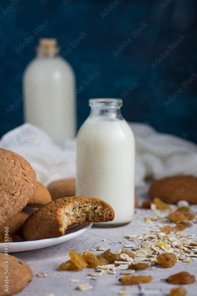 Healthy Breakfast with Oatmeal Cookies, Raisins, Oatmeal and Milk on a Dark Blue Background. Concept Healthy Eating