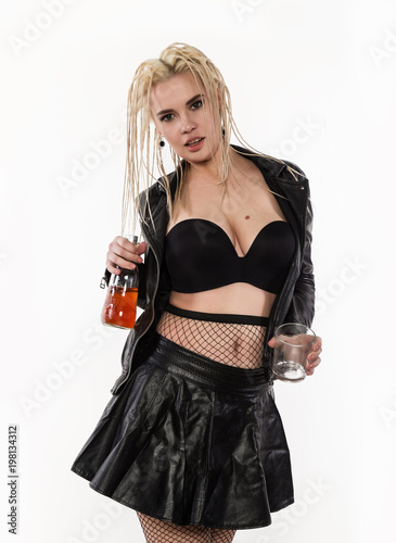 sexy woman with dreadlocks holding bottle adn glass of whiskey