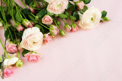 beautiful bouquet of gently pink roses and ranunculus on a pale pink background. close up. top view.copy space