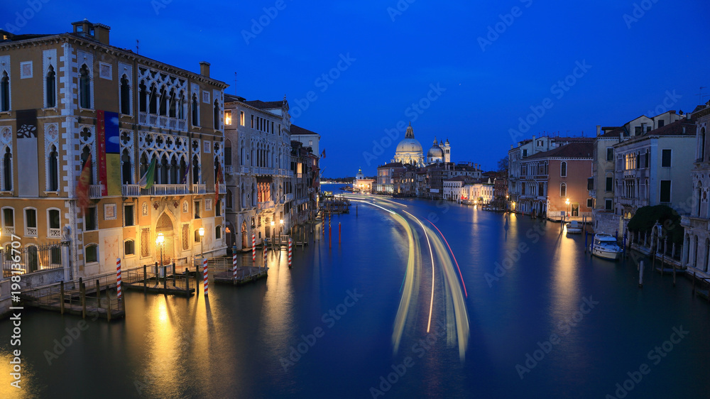 Gliding Into the Night of Beautiful Venezia ~ Evening scenery of Venice with light trails of boats & ferries on Grand Canal and Basilica di Santa Maria della Salute in the distant background