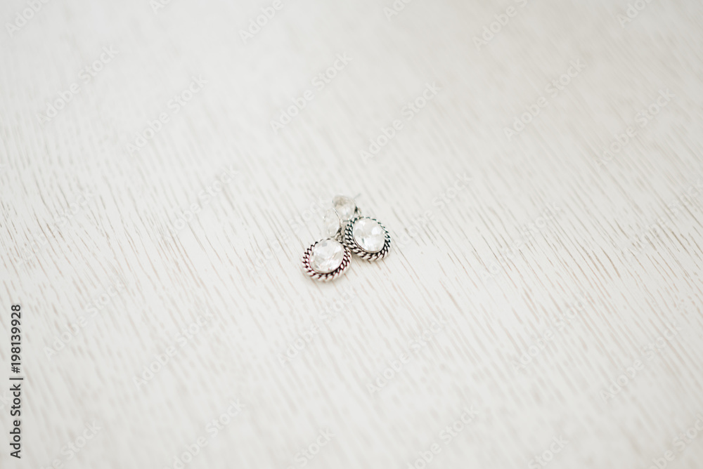 Women's wedding earrings on a light background, selective focus Women's wedding earrings on a light background, selective focus