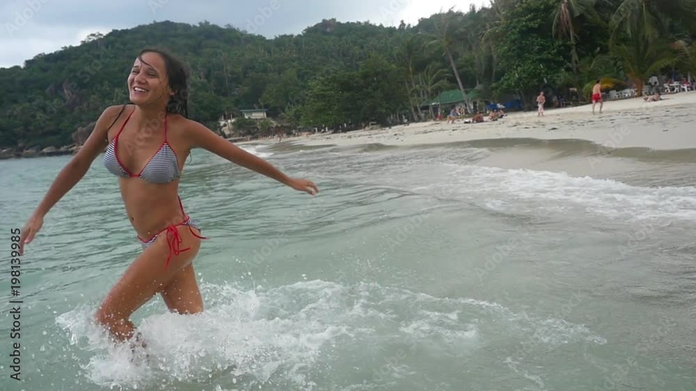 Playful young woman runs splashes in the sea enjoys vacation on tropical beach. slow motion. 1920x1080 Playful young woman runs splashes in the sea enjoys vacation on tropical beach. slow motion. 1920x1080