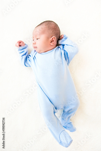 Newborn lovely cute baby lying on white sheet photo