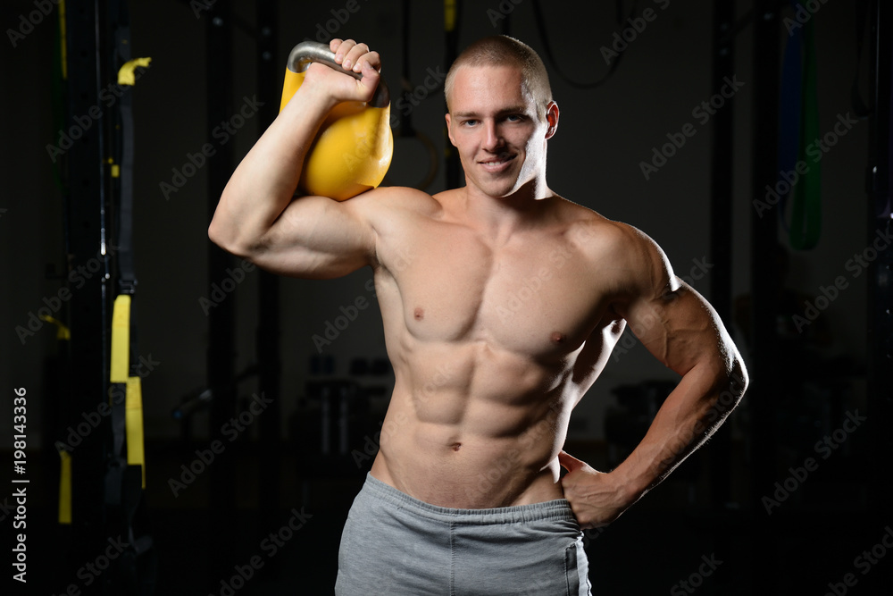 Handsome young man working out in gym kettlebell.. Handsome young man working out in gym kettlebell..