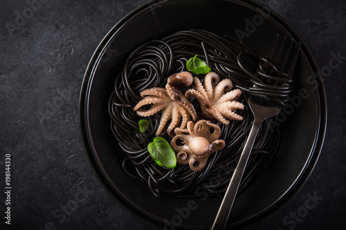 Vászonkép squid ink spaghetti pasta with octopuses in black bowl