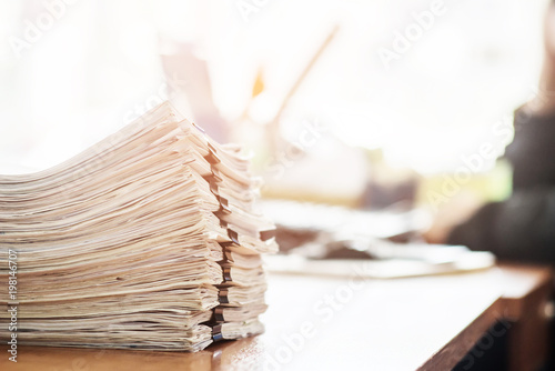 Paper documents stacked on wooden desk at workplace.Business Concept.