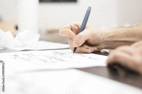 Woman make calligraphy writings, make art on a paper using pen brush and sign pen. Adult, old hands of a calligrapher man. Lifestyle image of a design process