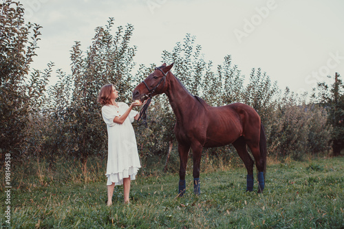 A woman feeds a horse