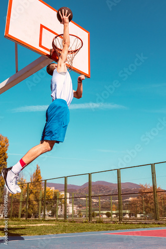 Young Basketball street player making slam dunk © FS-Stock