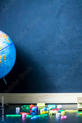 Education concept. Pencils place in front of chalkboard with colorful equipment on black background with copy space for text.