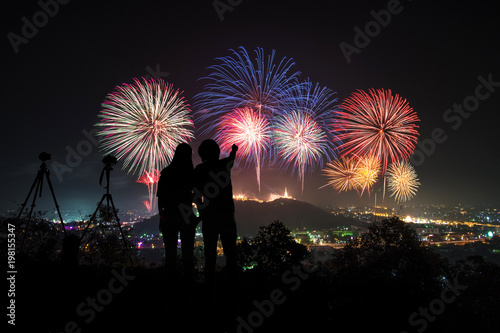 couple photographer looking at the firework display on top of the mountain in firework festival on holiday.Phanakornkiri Petchaburi Thailand.