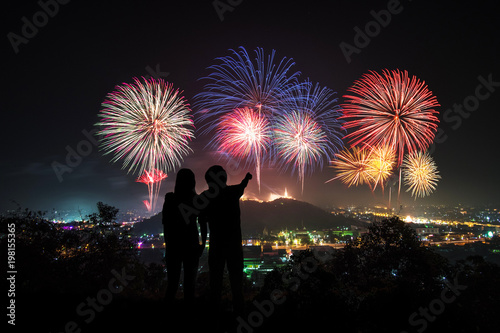 couple photographer looking at the firework display on top of the mountain in firework festival on holiday.Phanakornkiri Petchaburi Thailand.
