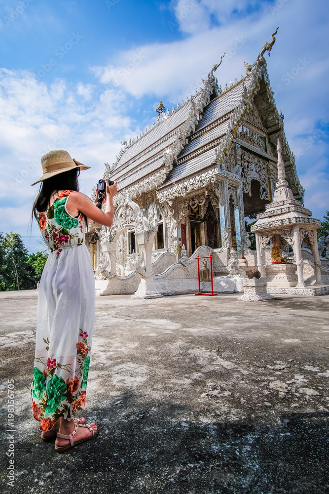 Naklejka premium woman traveler enjoying with beautiful white Buddha temple in Thailand. 