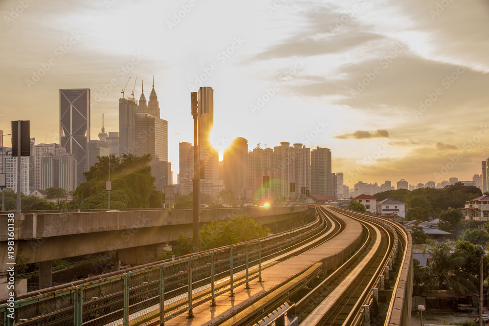 Sun rise brings a new day to the rapidly growing high tech city of Kuala Lumpur in Asia and is a good example of the regions booming economies and infrastructure - obrazy, fototapety, plakaty 