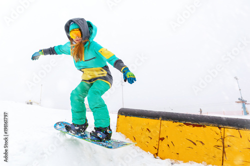 Young snowboarder jumping on ramp.