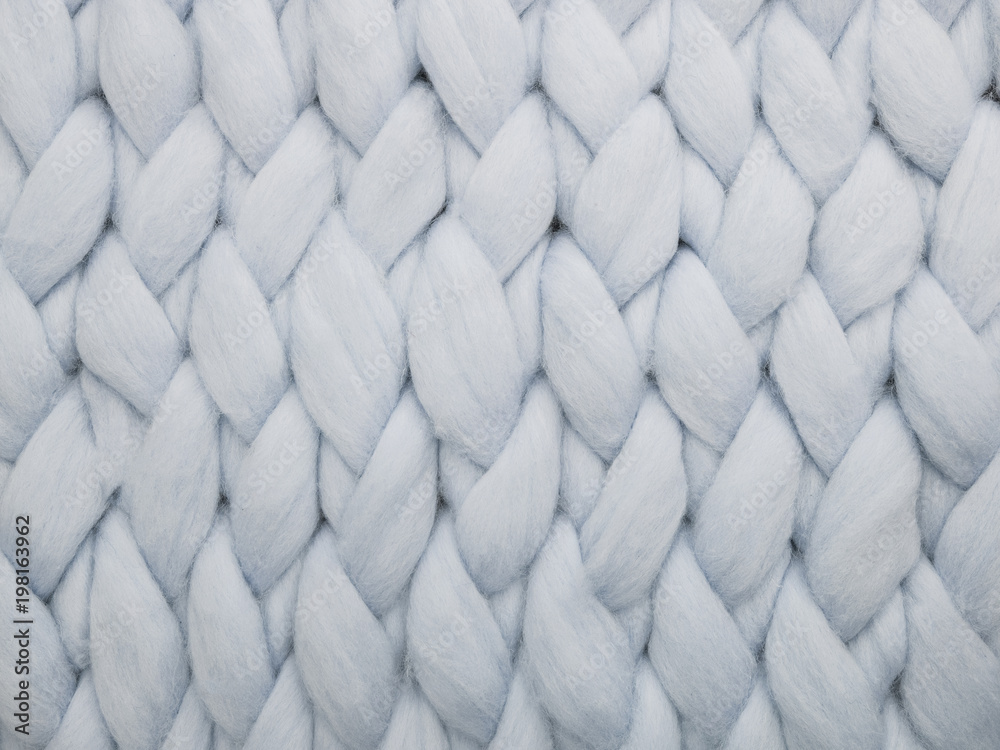 Merino wool handmade knitted large blanket, super chunky yarn, trendy concept. Close-up of knitted blanket, merino wool background Merino wool handmade knitted large blanket, super chunky yarn, trendy concept. Close-up of knitted blanket, merino wool background