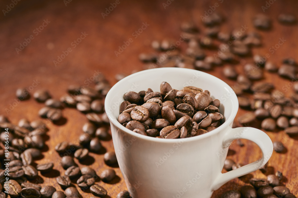Coffee beans in a cup on a dark wooden background Coffee beans in a cup on a dark wooden background