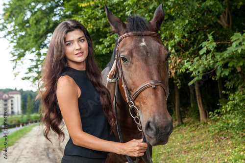 Pretty young woman and a brown horse © alexandco