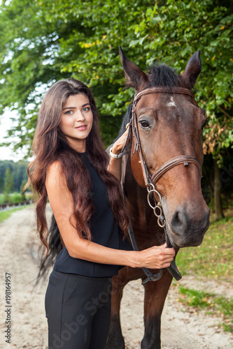 Pretty young woman and a brown horse