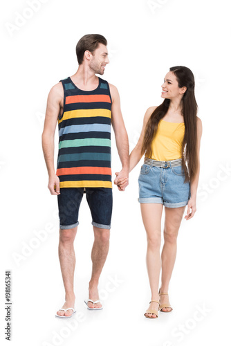 smiling couple holding hands and looking at each other, isolated on white