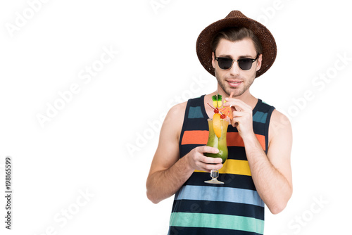 man in sunglasses and hat holding glass with cocktail, isolated on white