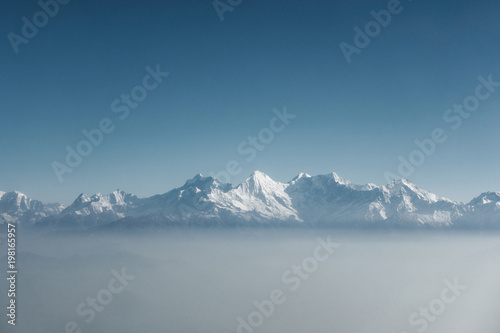 The Himalayas as seen from an airplane in Nepal. Layer of clouds beneath the mountain tops. 