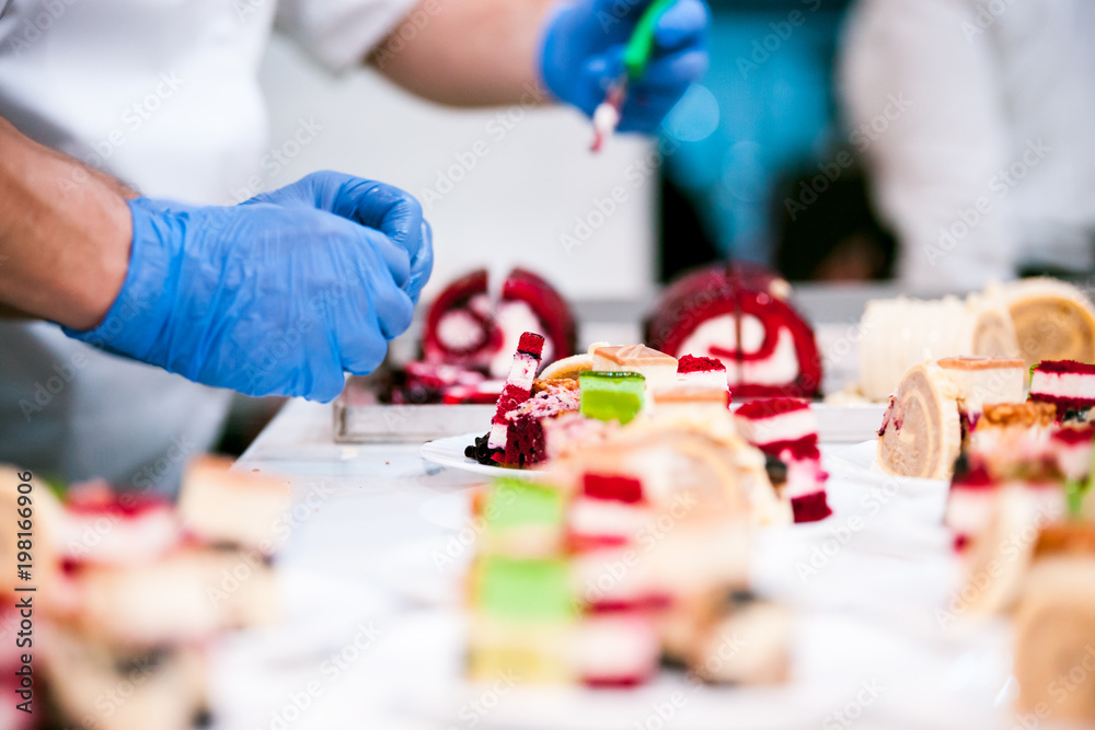 Obraz premium Confectioner preparing cakes for party at pastry shop