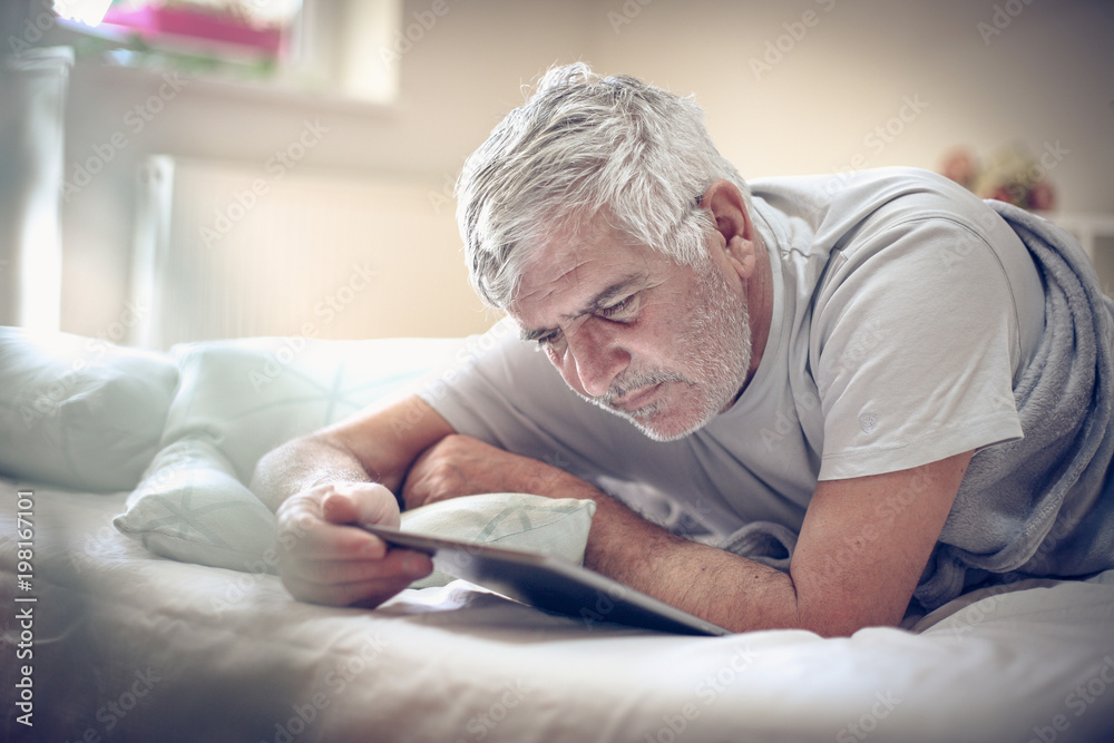 Using digital tablet in bed. Using digital tablet in bed.