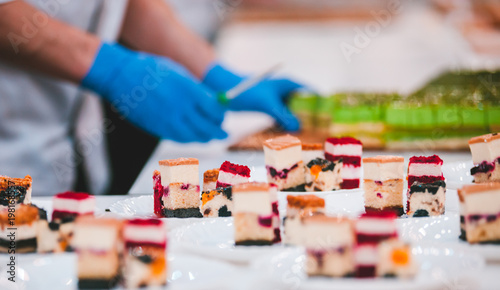 Different types of cakes on plates prepared in pastry shop
