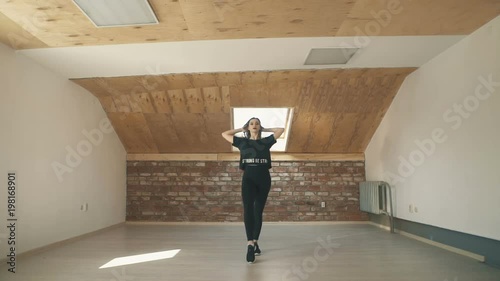 beautiful athletic girl in black dancing vogue or hip hop and jumping. long shot. Wide shot.