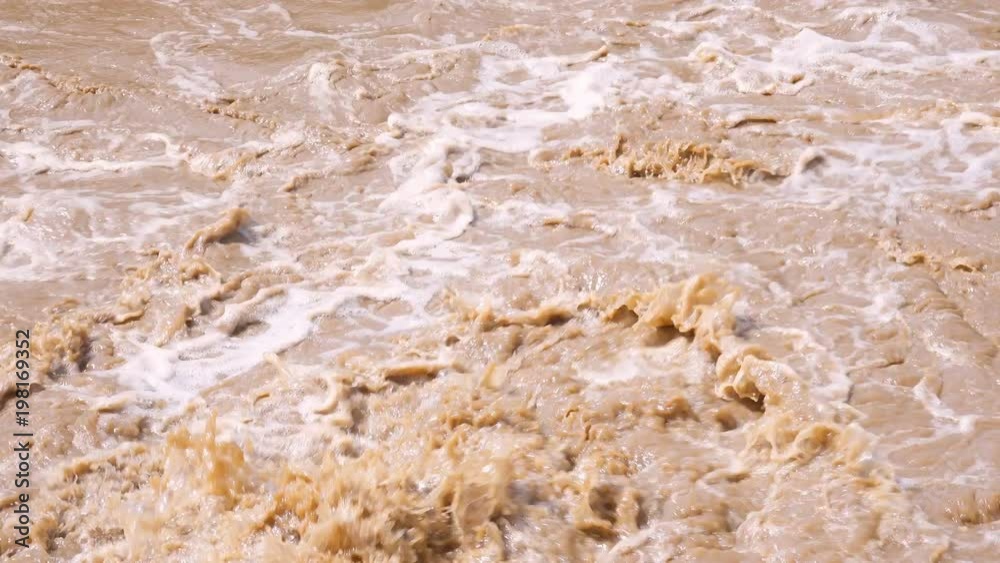 Muddy water churning behind motor boat in river detail 4K