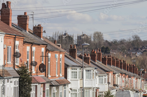 Row of terraced house roofs with chimney stacks