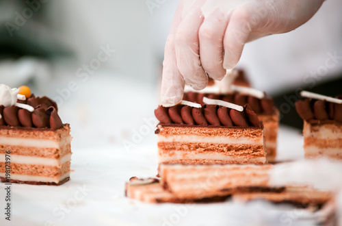 Slika na platnu Confectioner decorating cake in pastry shop, confectionery