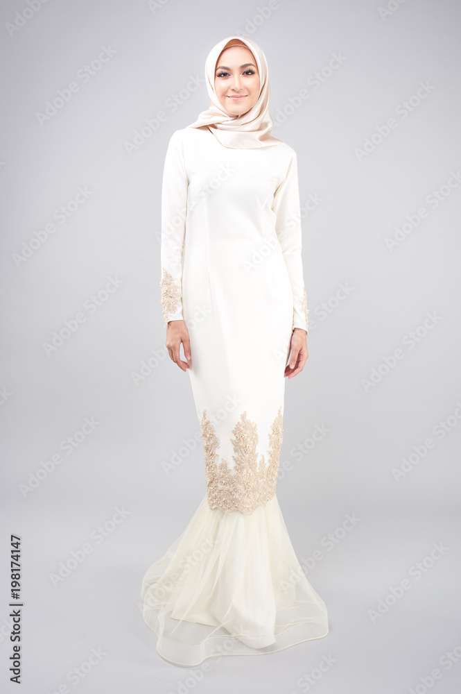 Hijab Fashion Portraiture.Beautiful girl wearing Baju Kurung and Hijab.Studio shoot with grey background. Hijab Fashion Portraiture.Beautiful girl wearing Baju Kurung and Hijab.Studio shoot with grey background.